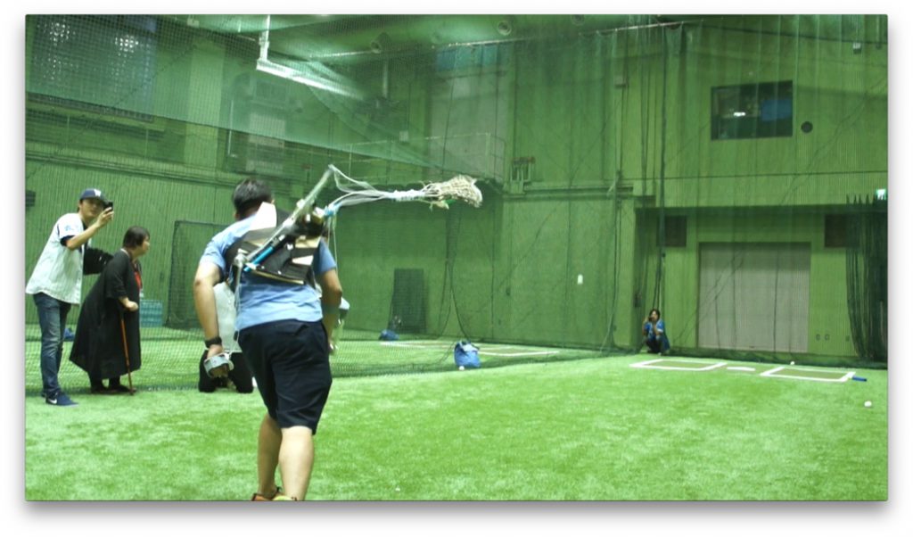 「超☆野球」で機械の「第三の腕」を使って投球する選手