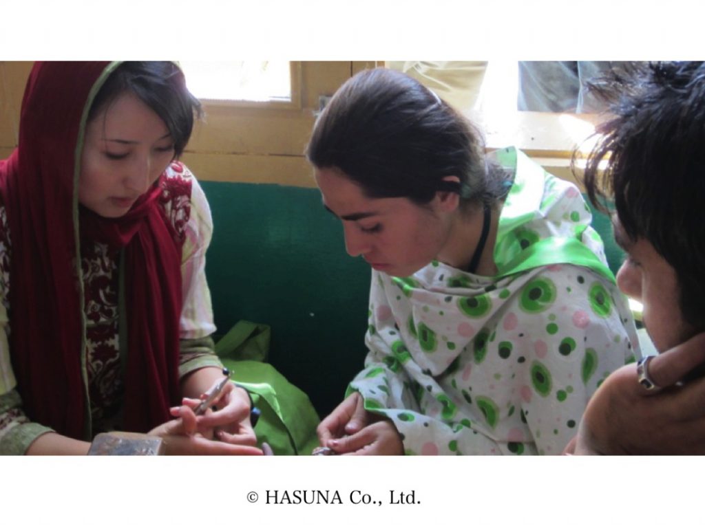 イスラム教圏のスカーフ「ヒジャブ」を被り、現地のパキスタン女性と一緒に研磨する白木さん（左）